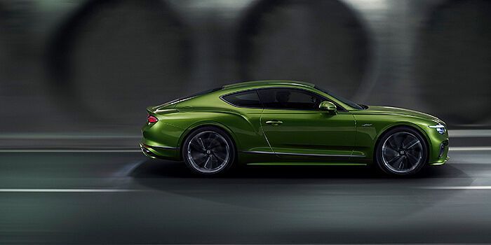 Bentley Taichung Bentley Continental GT coupe in Tourmaline Green paint driving in profile on a dark road