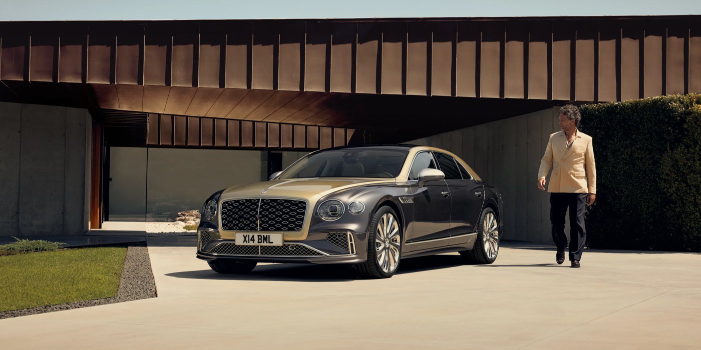 Bentley Taichung Bentley New Flying Spur Mulliner V8 hybrid sedan front three quarters in Rose Gold over Magnetic paint, parked near modern home