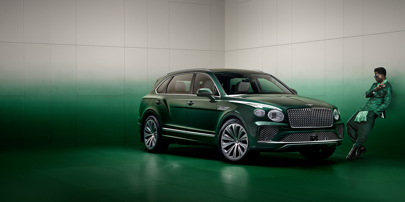 Bentley Taichung Wisdom K leans against wall next to Bentley Bentayga Extended Wheelbase Atelier Edition SUV in Light Emerald green paint