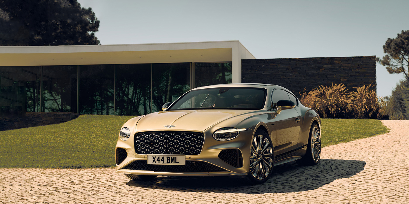 Bentley Taichung Bentley Continental GT Mulliner coupe front three quarters in Patina paint parked outside a glass fronted building with a grass lawn behind it
